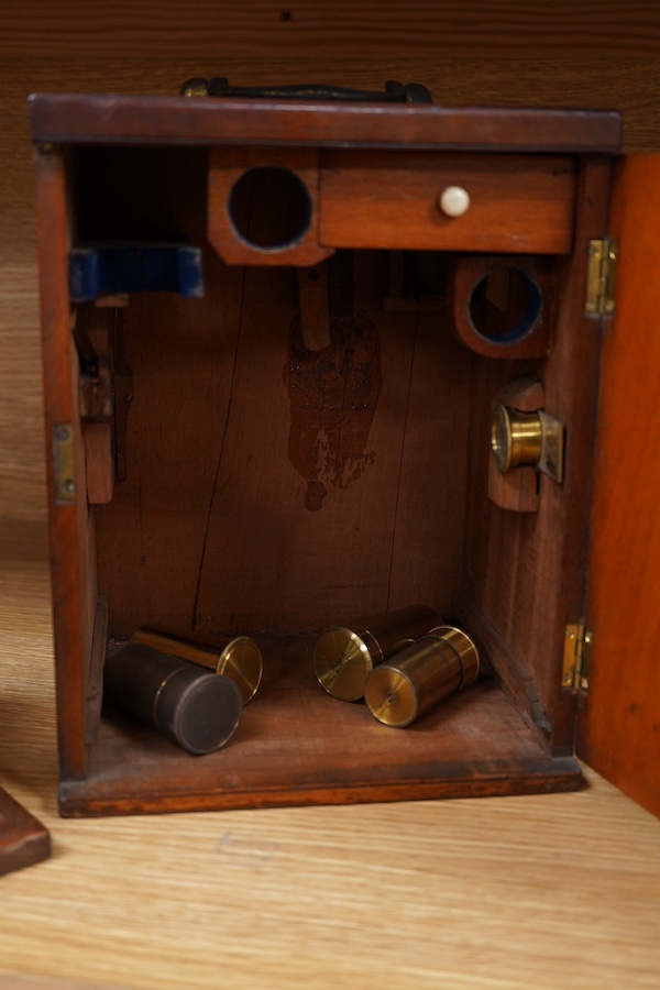 A mid 19th century brass compound monocular microscope, by J & C Robbins, 9, Bartholomew Close, London, with accessories and various slides, raised on a wooden base, the case 25cm high